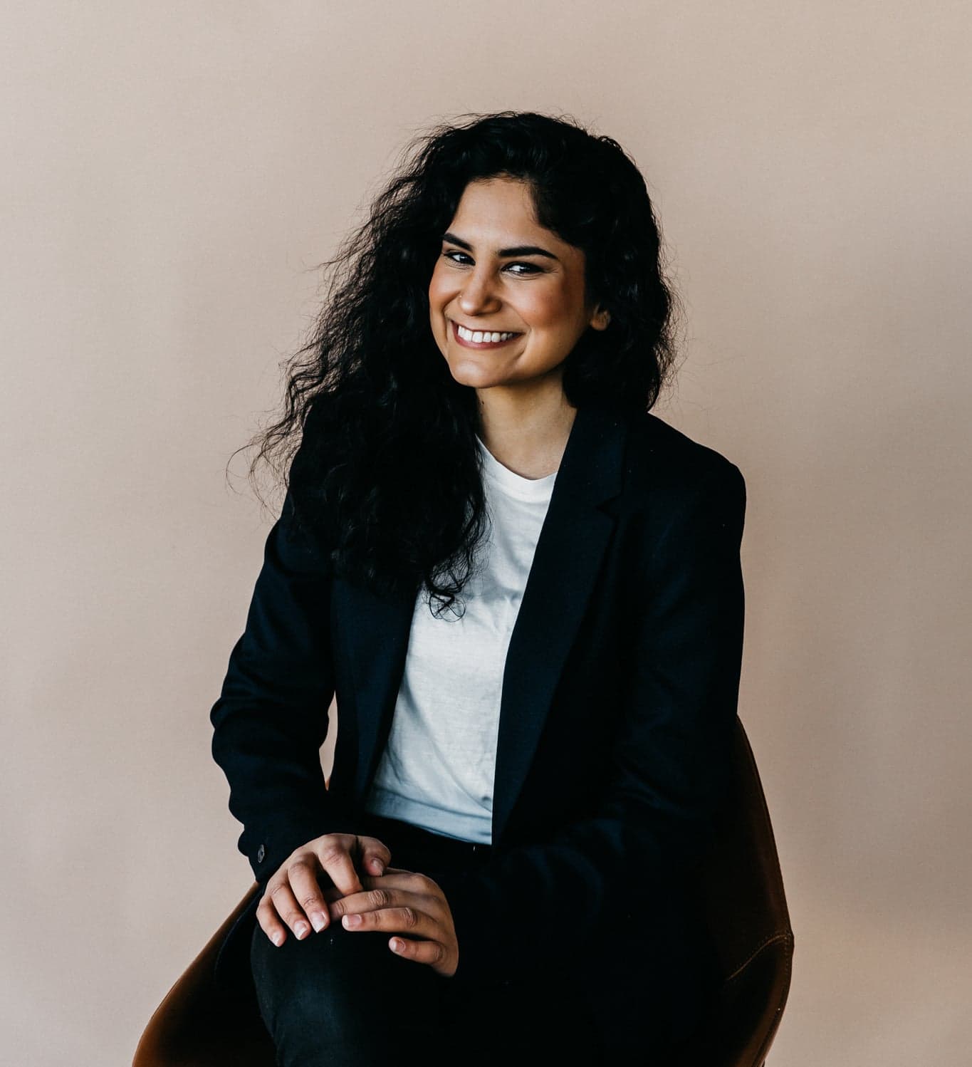 Alisha Esmail, AI operations consultant, in a studio portrait wearing a black blazer